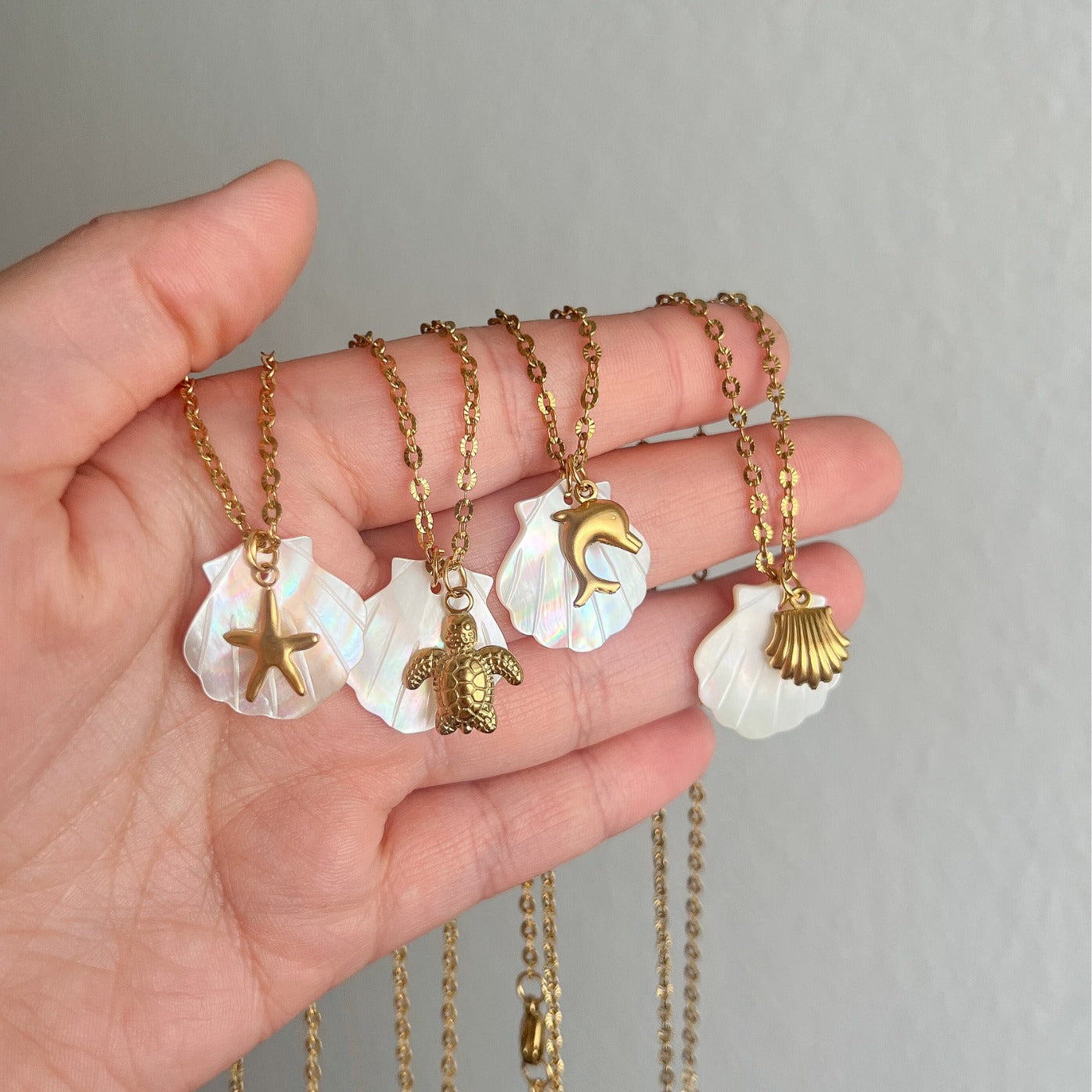 Collar con colgante de acero de titanio chapado en oro de 18 quilates con diseño de estrella de mar, delfín y concha de playa, estilo marinero, venta al por mayor